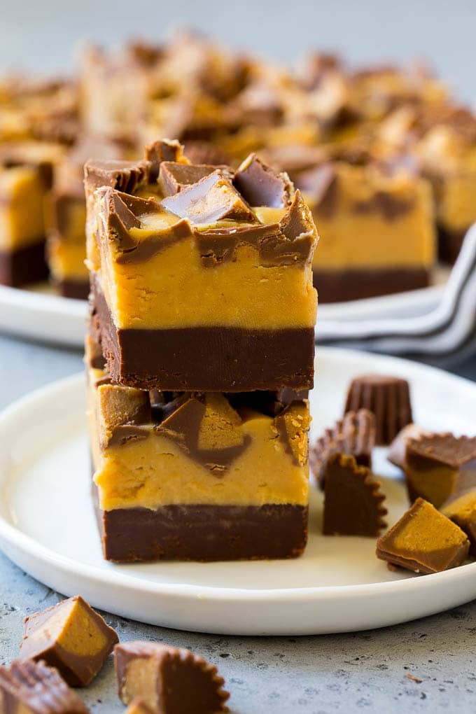 Stacked pieces of chocolate peanut butter fudge on a plate.