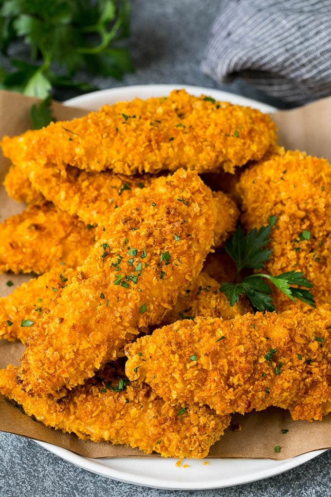 Cornflake chicken on a serving plate, garnished with fresh parsley.