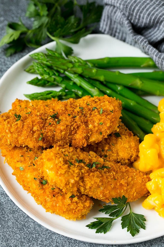 Cornflake crusted chicken fingers served with asparagus and mac and cheese.