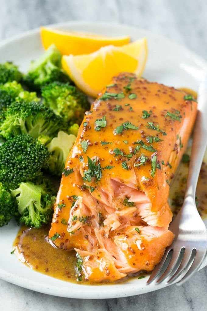 A plate with a honey mustard salmon fillet and cooked broccoli.