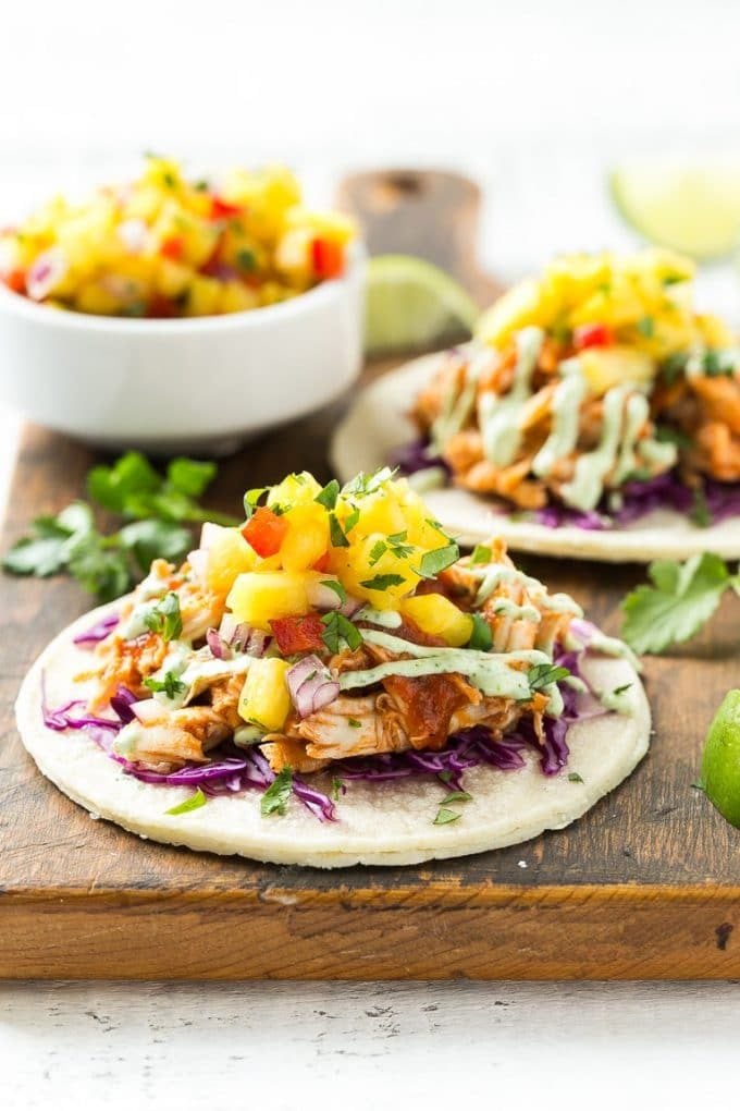 A tortilla topped with cabbage, pulled chicken and pineapple salsa.