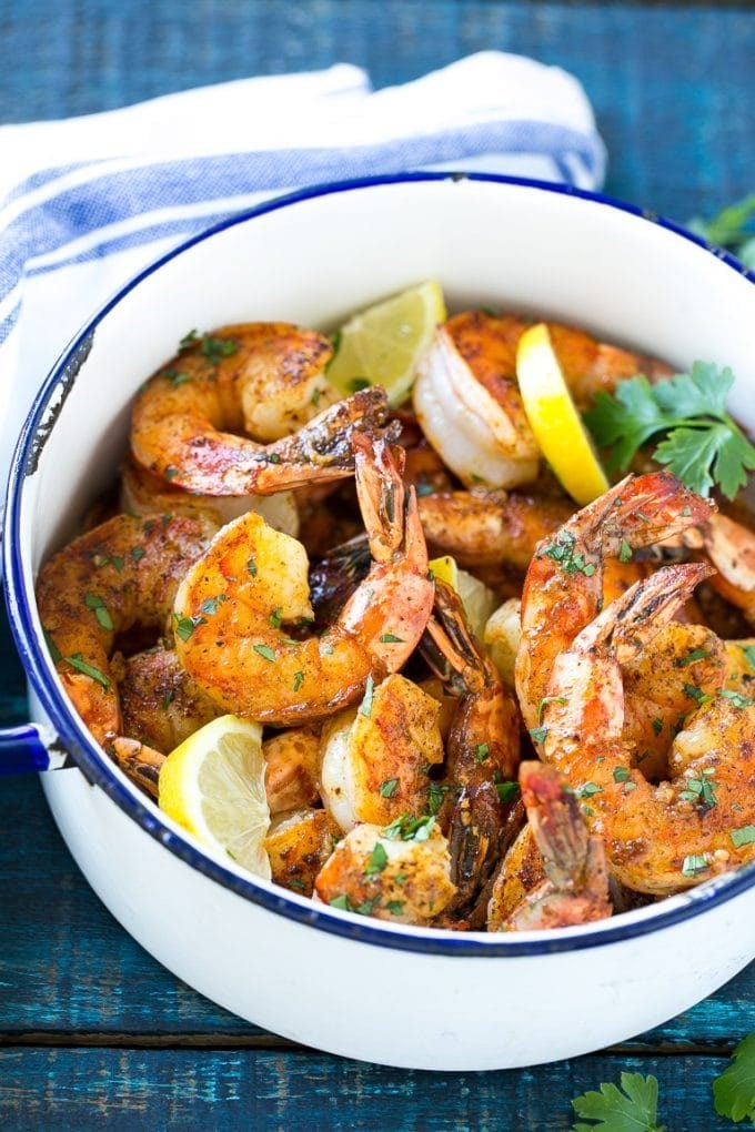 Giant shrimp cooked in a spiced butter sauce, then garnished with lemon slices and chopped parsley.