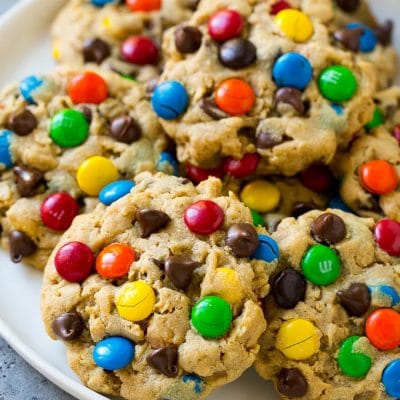A plate of monster cookies which are made with oats, peanut butter, chocolate chips and M&M's.