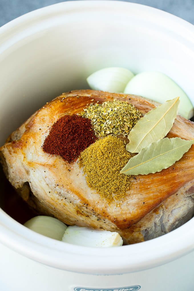 Pork roast with spices and onions in a slow cooker.