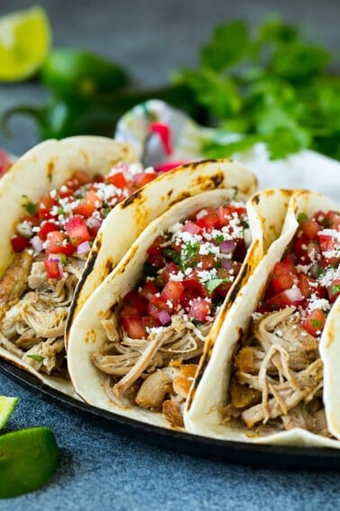 Pork tacos in flour tortillas topped with pico de gallo.