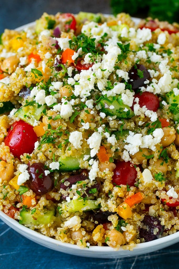 A bowl of Mediterranean quinoa with colorful vegetables and feta cheese.