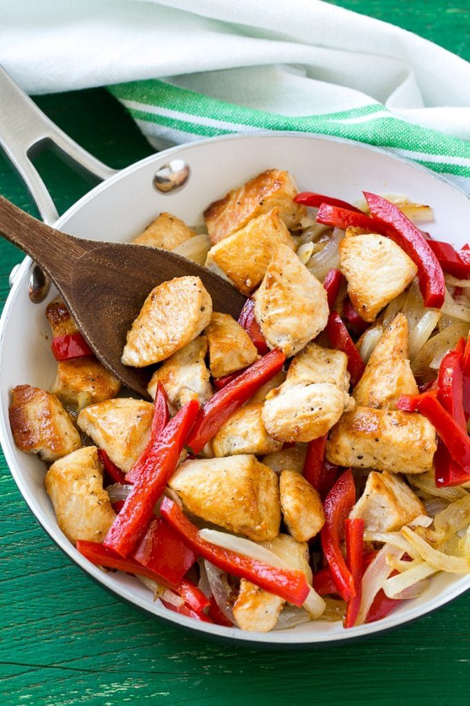 A pan with seared chicken, onions and peppers.