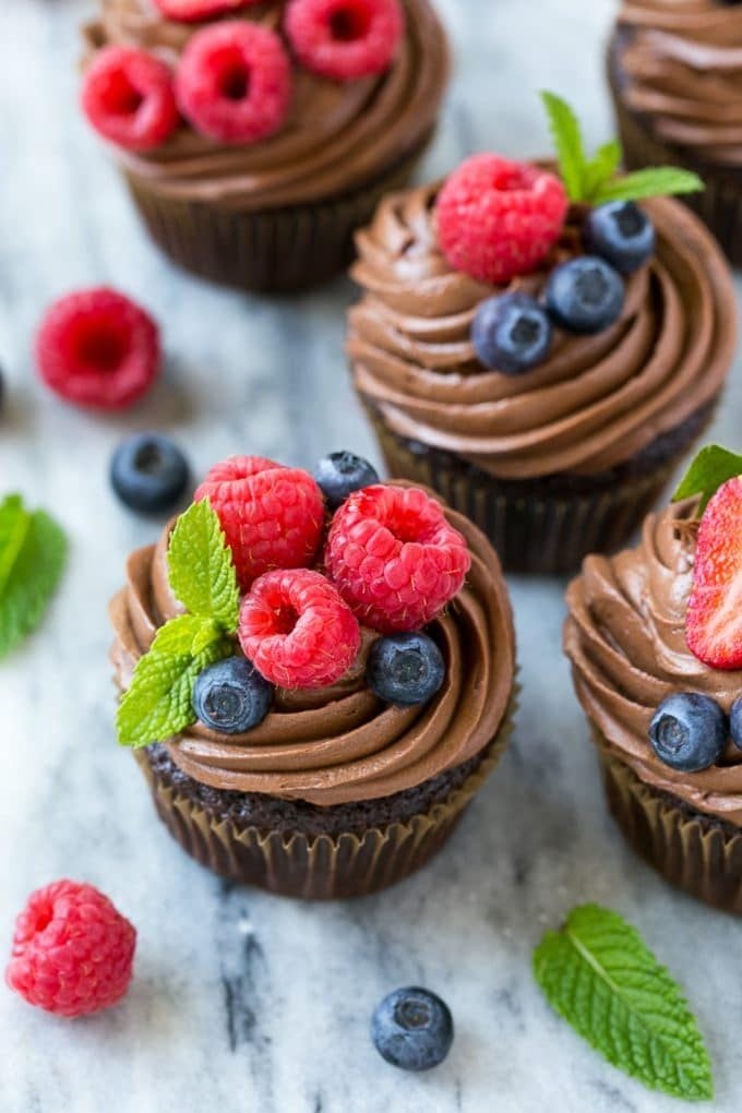 Chocolate hazelnut cupcakes topped with fresh berries and mint.