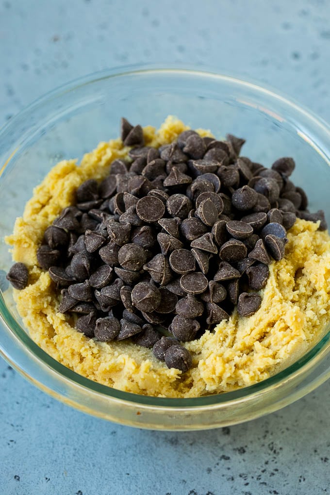 A bowl of cookie dough with chocolate chips on top.