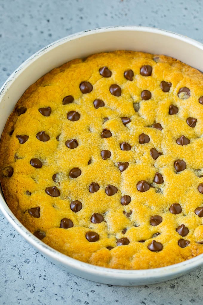 A giant chocolate chip cookie inside a pan.