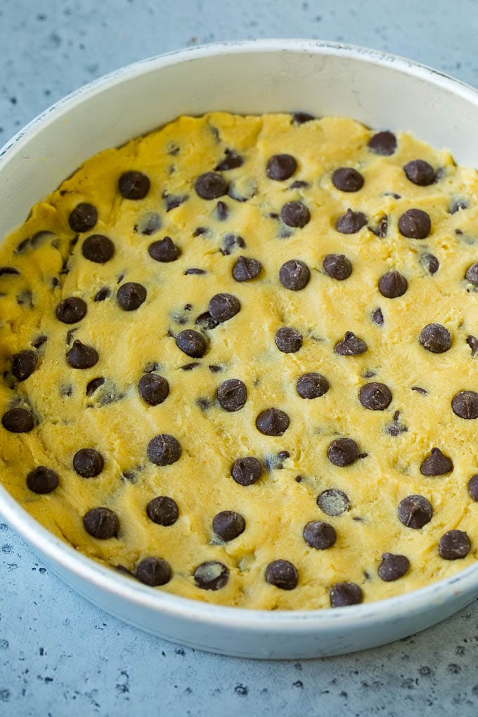Chocolate chip cookie dough pressed into a cake pan.