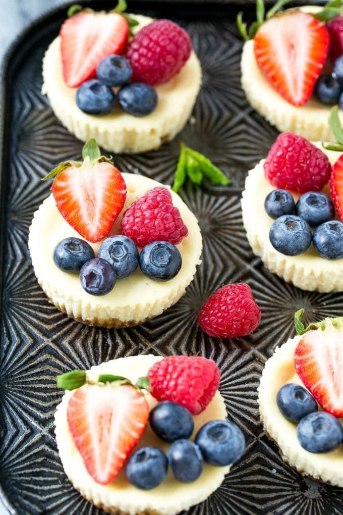Individual Greek yogurt cheesecakes topped with blueberries and raspberries.
