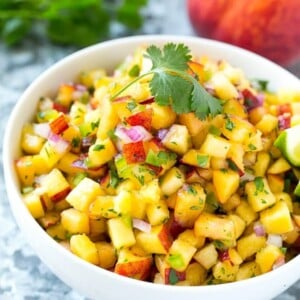 This recipe for peach salsa is the ultimate summer condiment. Juicy ripe peaches, herbs, and a bit of jalapeno creates a sweet and spicy salsa that's perfect with chips, on fish or chicken, or even on a sandwich! #adv