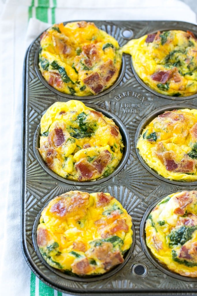 This recipe for breakfast egg muffins is an easy grab and go option for busy mornings. The protein packed egg muffins are loaded with bacon, cheddar cheese and spinach for maximum flavor! #ConquerTheExpected #ad