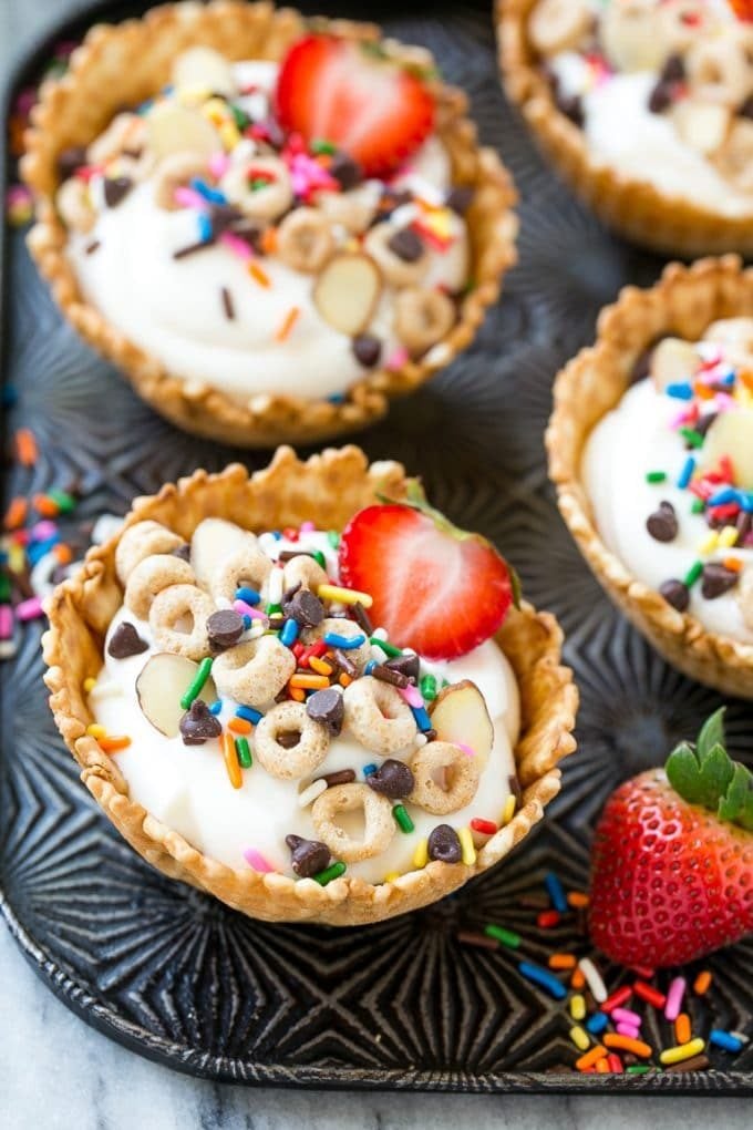 Breakfast sundae cups with vanilla yogurt and cereal inside.