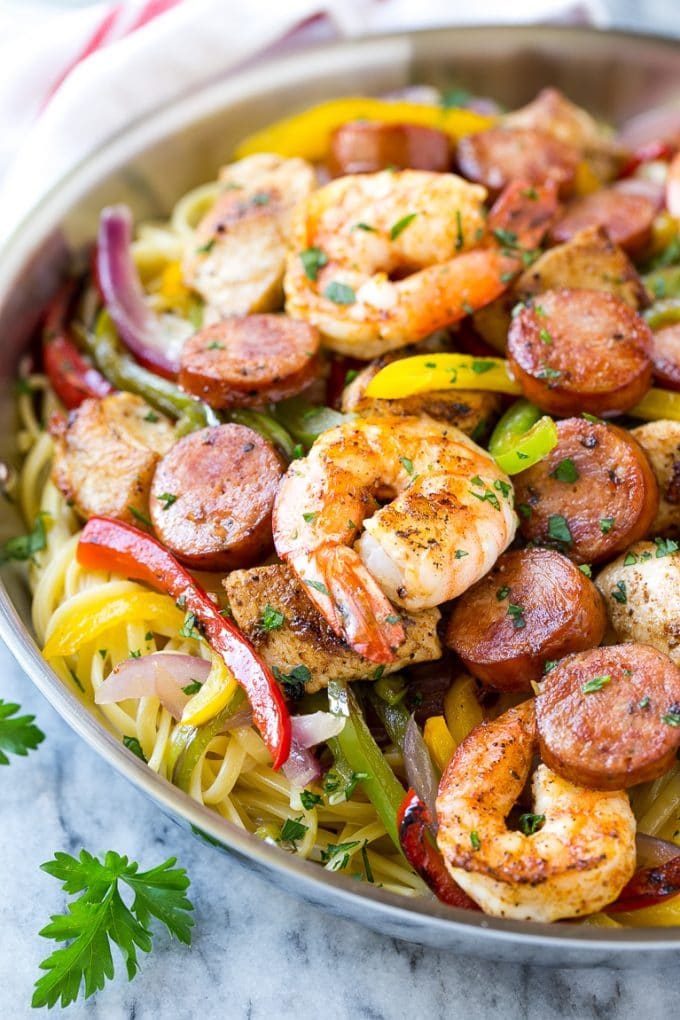 A pan of jambalaya pasta with spiced chicken, shrimp, sausage, peppers and onions.