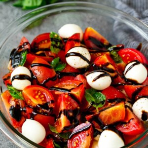 Caprese salad with tomatoes, fresh mozzarella, basil leaves and balsamic glaze.