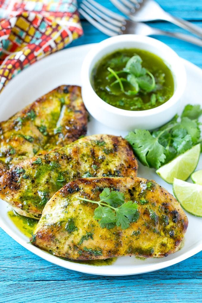 Cilantro lime chicken topped with sauce and served with lime wedges.