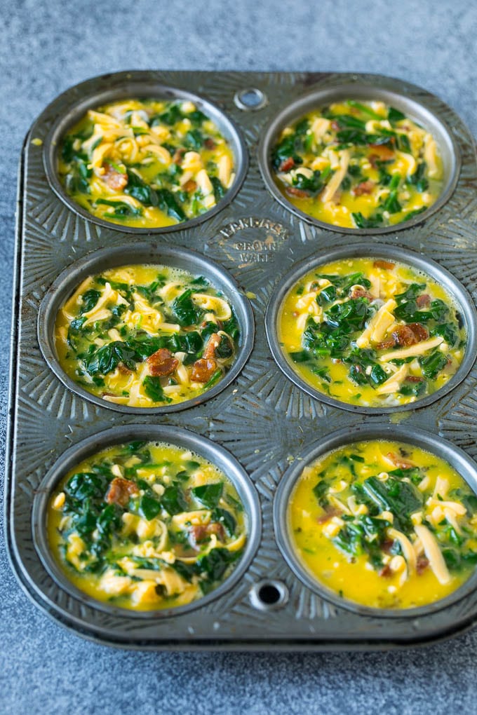 Uncooked egg muffins in a muffin tin.