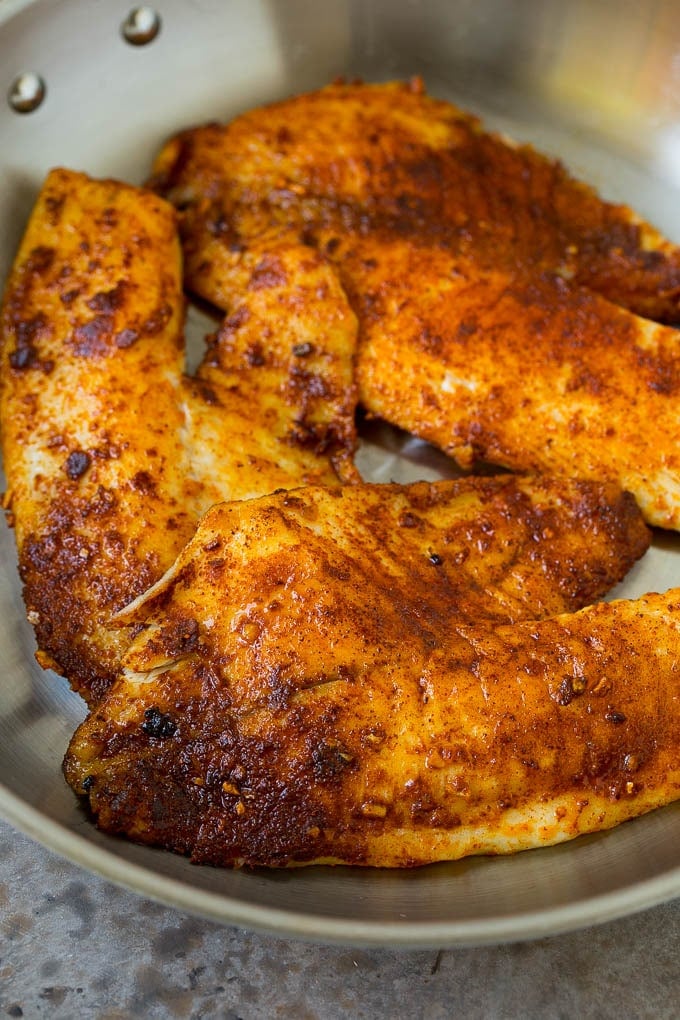 Tilapia fillets coated in taco seasoning and cooked in a skillet.