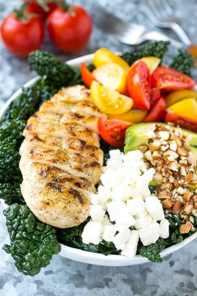 Tuscan kale salad with red and yellow tomatoes and sliced grilled chicken.