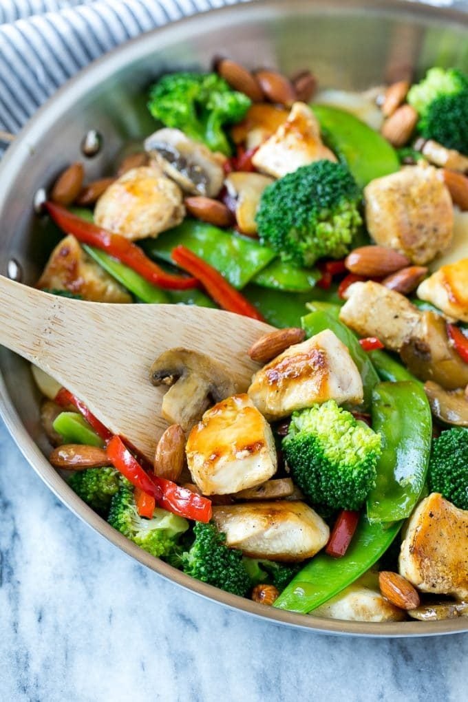 A pan of chicken almond ding with a serving spatula in it.