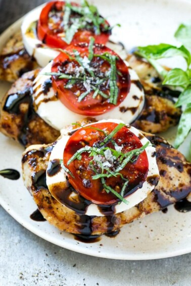 This recipe for chicken caprese is grilled seasoned chicken, topped with fresh mozzarella, ripe tomatoes, basil and balsamic reduction. A quick and easy dinner that's easy enough for a busy weeknight but special enough to serve to company!