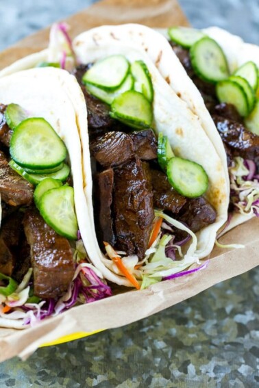 This recipe for Korean BBQ Tacos is marinated and seared beef layered with cabbage slaw and marinated cucumbers, all tucked into warm flour tortillas. A unique take on taco night that's a real crowd pleaser! #ad