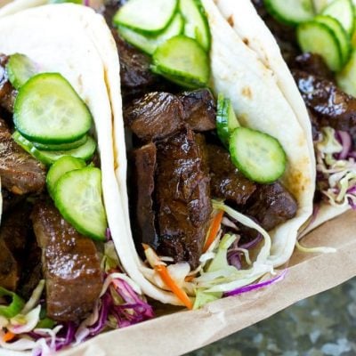 This recipe for Korean BBQ Tacos is marinated and seared beef layered with cabbage slaw and marinated cucumbers, all tucked into warm flour tortillas. A unique take on taco night that's a real crowd pleaser! #ad