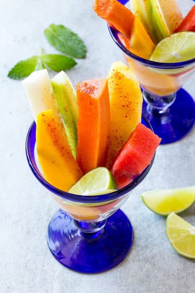 Spears of colorful fresh fruit, cucumbers and jicama in Mexican fruit cups.