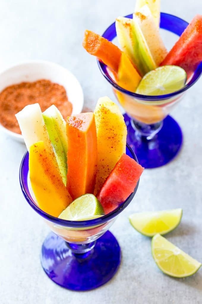 Spears of watermelon, cucumber, jicama, mango and pineapple in glasses.