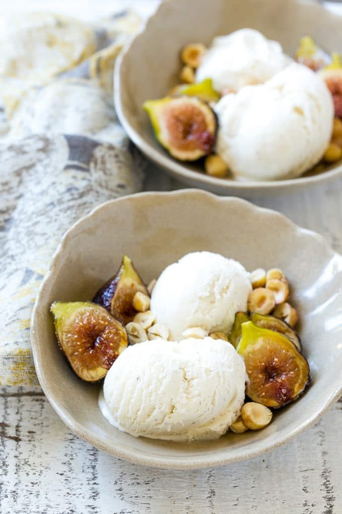 Small serving bowls of vanilla ice cream, roasted figs and chopped nuts.