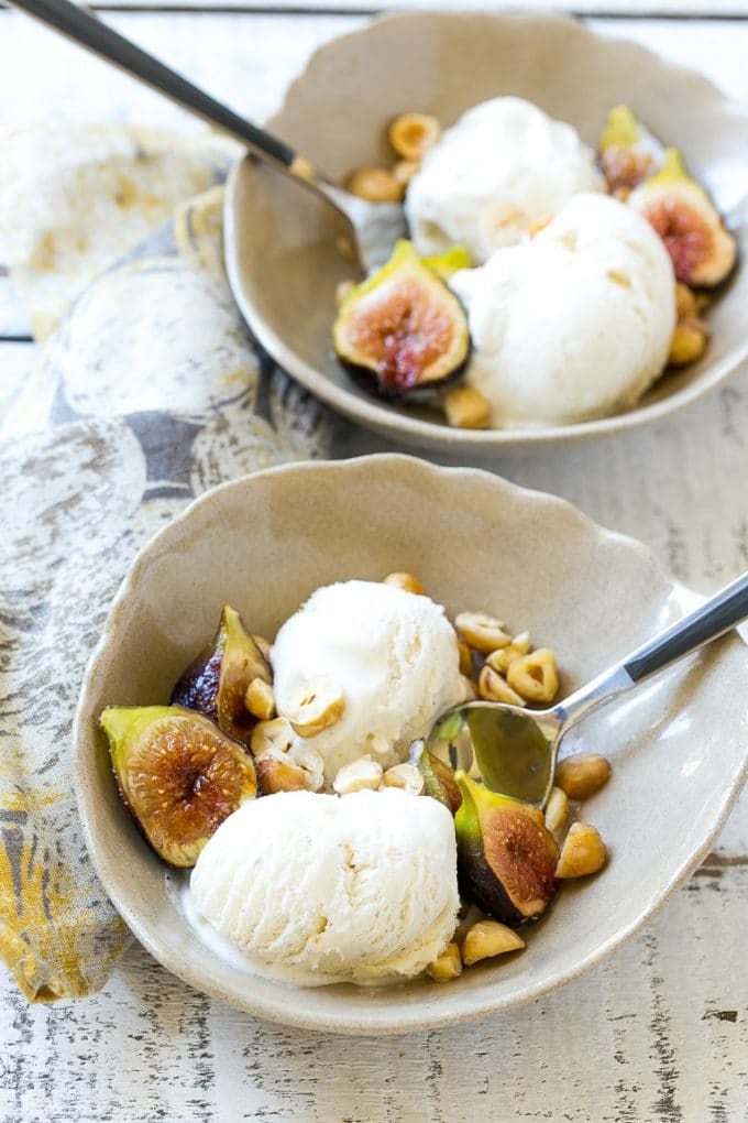Vanilla ice cream with roasted figs and hazelnuts in a bowl.