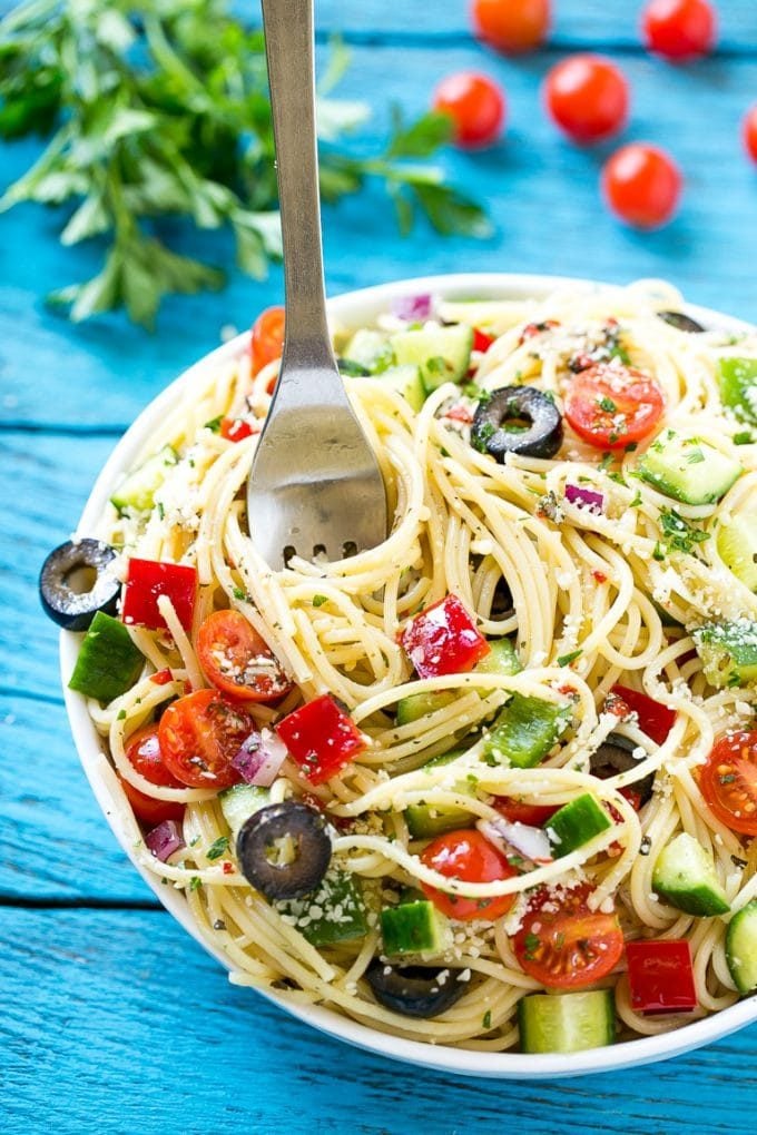 A bowl of spaghetti salad with a serving fork in it.