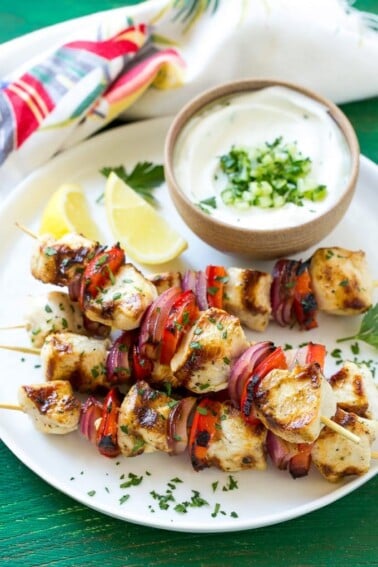 This recipe for Greek chicken kabobs is garlic and herb marinated chicken and colorful vegetables, skewered and grilled to perfection. Serve these skewers with a creamy cucumber yogurt dip for an easy and delicious dinner!