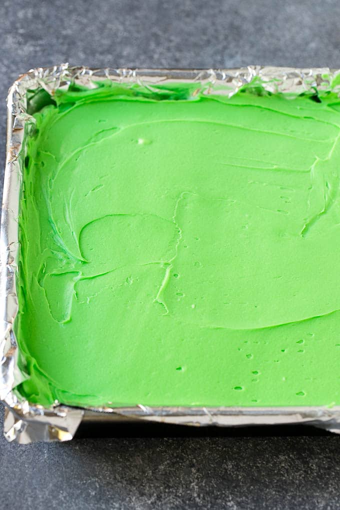 A layer of green mint frosting spread on top of brownies.