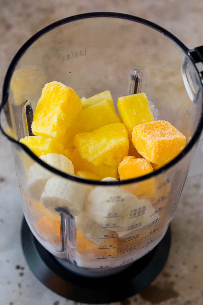 Pineapple, mango, banana and coconut milk in a blender.