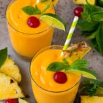 Tropical smoothies garnished with mint, limes and pineapple.