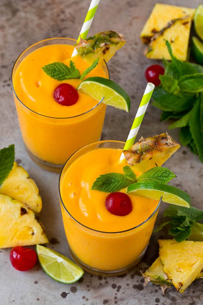 Tropical smoothie garnished with mint, limes and pineapple.