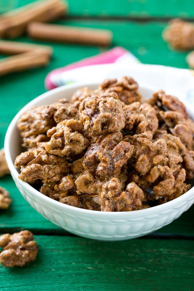 A white bowl filled with candied walnuts.