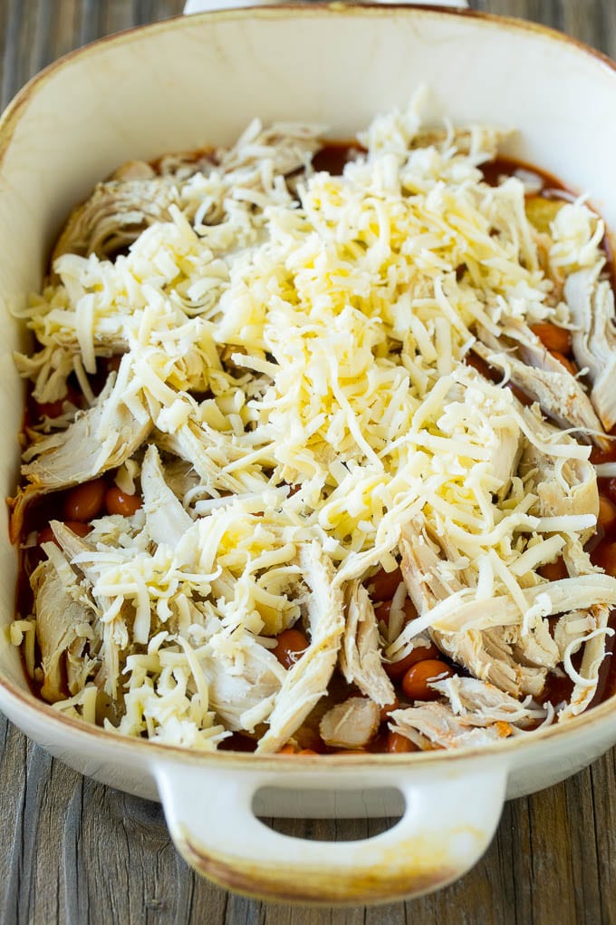 Chicken, beans and shredded cheeses in a casserole dish.