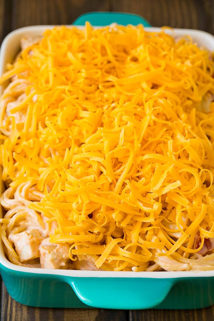 A baking dish of creamy spaghetti topped with cheese.