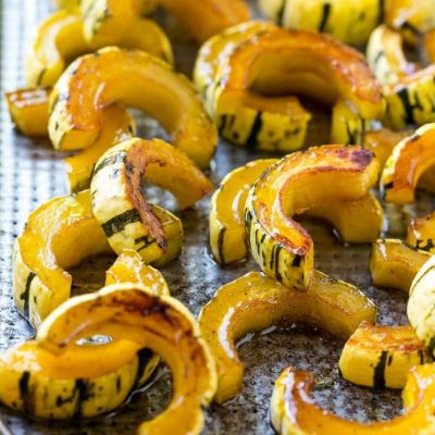 This delicata squash recipe is roasted with brown sugar, maple syrup and cinnamon for a sweet and savory side that's perfect for fall and winter meals.