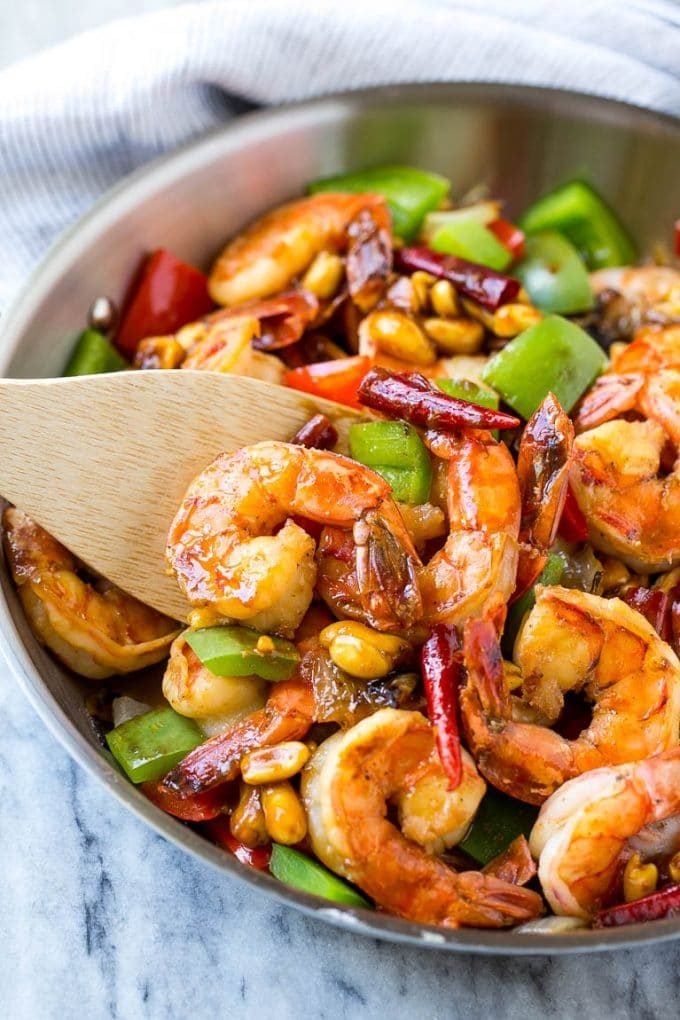 A skillet of spicy shrimp with peanuts and vegetables.