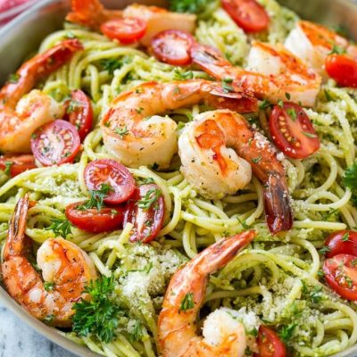 This recipe for shrimp pesto pasta is spaghetti tossed in a flavorful pesto sauce, then topped with sauteed shrimp and tomatoes. A fresh and easy dinner that's quick to make and packed with flavor!