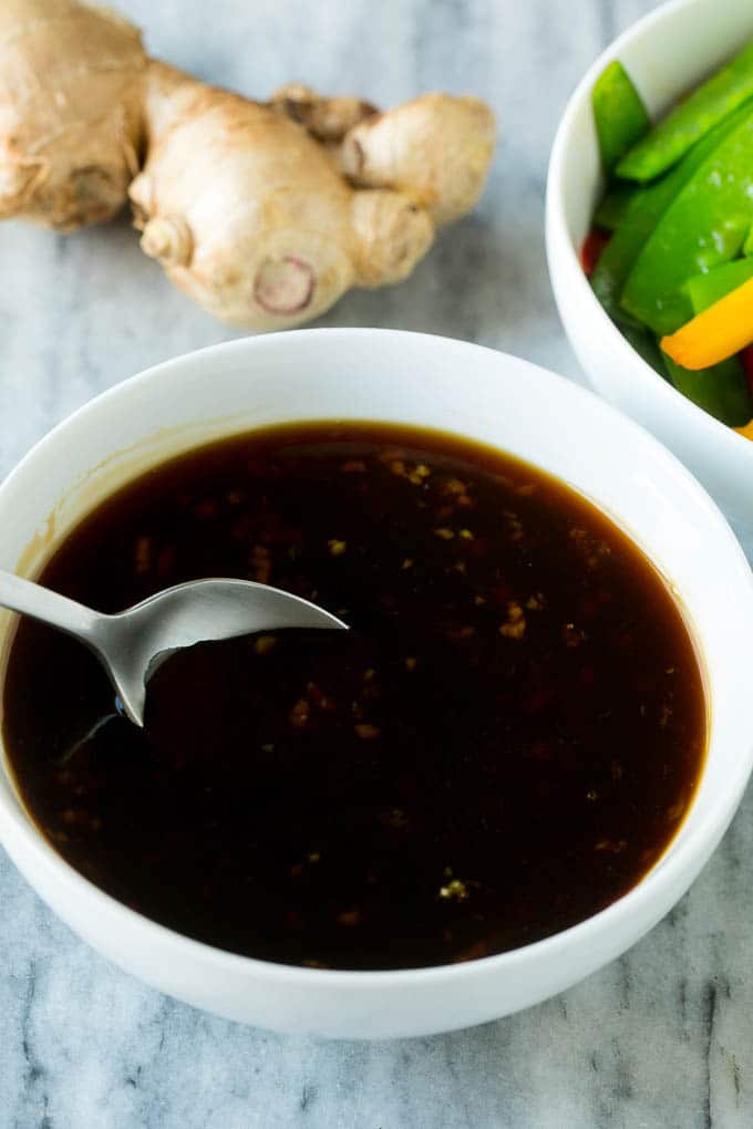 A bowl of homemade teriyaki sauce with a spoon in it.