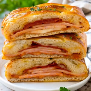 A stromboli recipe with pepperoni, ham and cheese wrapped up in pizza dough and baked.