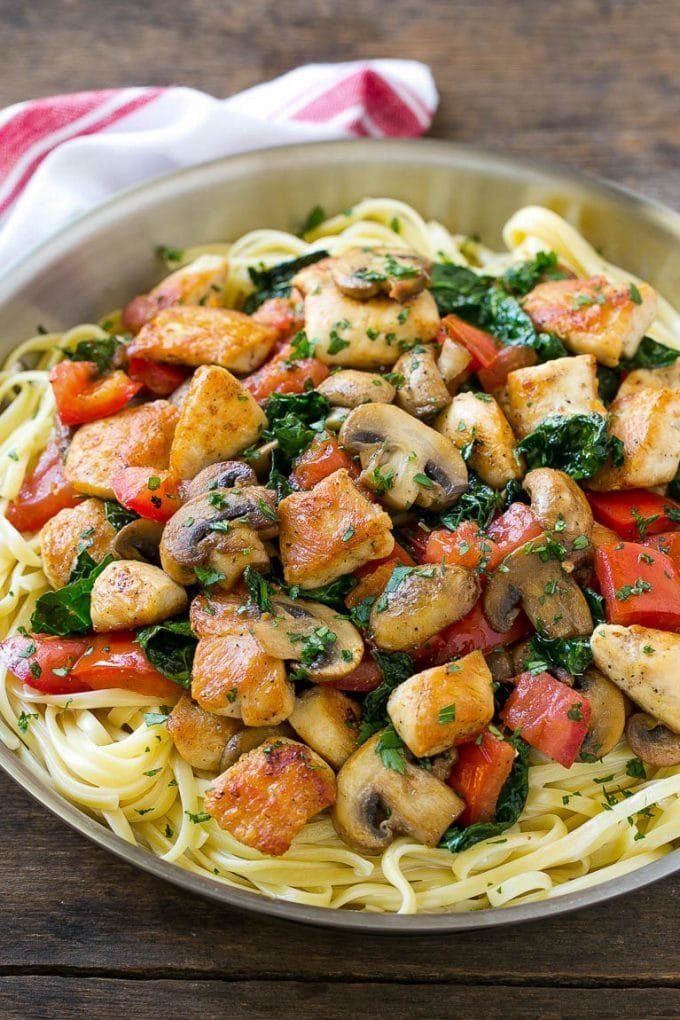 Chicken pasta in a creamy Tuscan sauce with mushrooms, kale and fresh tomatoes.