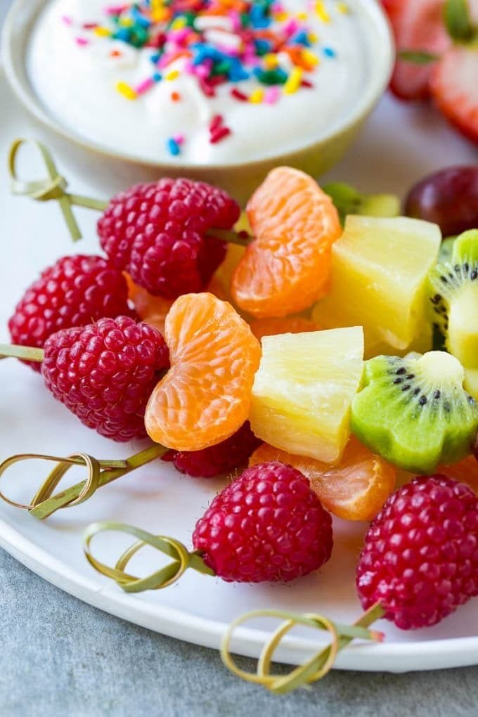 Fruit kabobs made with kiwi, raspberries, grapes and oranges, and served with a dipping sauce.