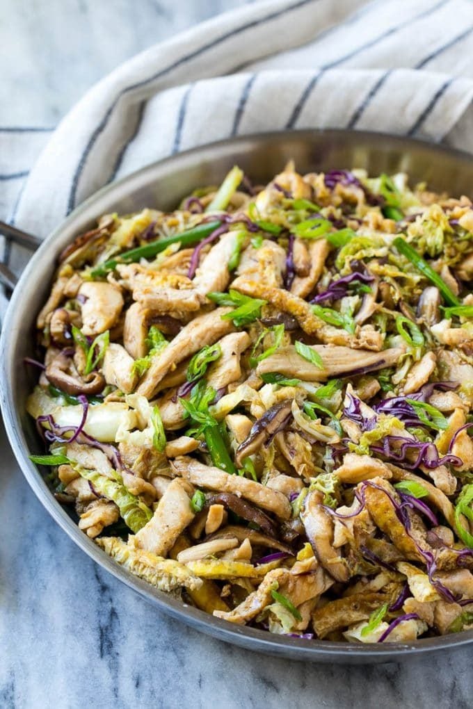 A skillet of moo shu chicken with eggs, cabbage and mushrooms.